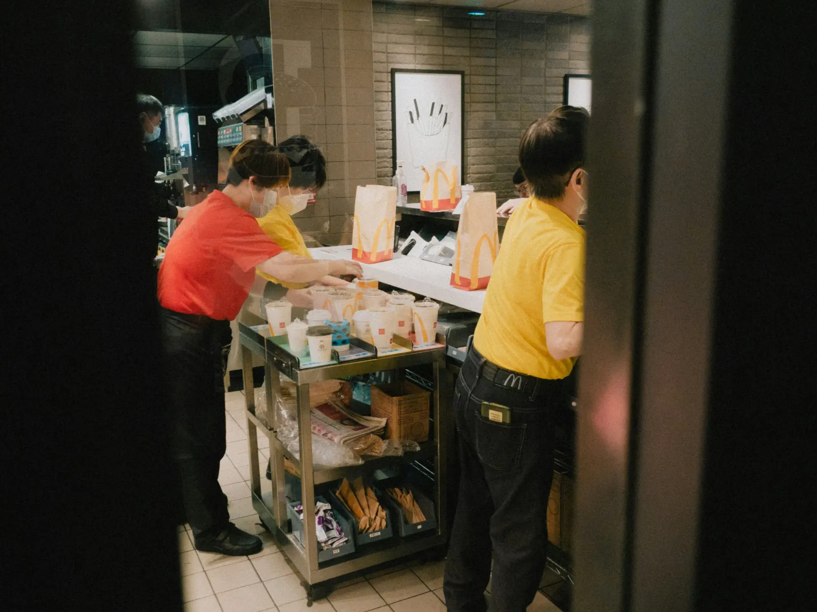 McDonald's employees in uniform preparing orders behind the counter